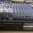 Kombinovaný mixážní pult s modrými knoflíky a stříbrnými prvky. Na přední straně je nápis PreSonus STUDIOLIVE AR12c 24 Bit | 96kHz. Zadní strana obsa…