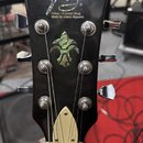 Černá hlava kytary s chromovanými ladičkami. V horní části je bílé logo a nápisy „Fokus - H Guitar Shop“ a „Made for Czech Republic“. Uprostřed je oz…