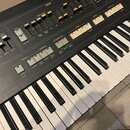 Detailní pohled na ovládací panel a klávesnici elektronického nástroje. Na panelu jsou viditelné nápisy ORGAN, PERCUSSIVE, DECAY, BRILLIANCE, SUSTAIN…
