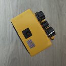 Žlutý kytarový efekt s třemi černými oválnými knoflíky. Na boku je umístěn vstup pro napájení a štítek s nápisem USE BOSS PS- ADAPTOR ONLY (9V DC). P…