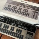 Na fotografii je analogový basový sekvencer v kovovém provedení s černým ovládacím panelem a šedými tlačítky. Na přístroji je nápis DONNER SYN BASS A…
