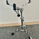 Chromovaný stativ na instrument s třemi černými gumovými oporami. Konstrukce je kovová, v dolní části má rozkládací trojnožku s černými gumovými konc…