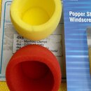 Dvě pěnová plíšivka na mikrofon, jedna žlutá a jedna červená. Vedle nich je modré obalové balení s nápisy A58WS-YEL, YELLOW a Popper St Windscre. Pod…