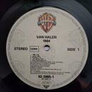 Fotografie zachycuje štítku vinylové desky s logem RECORDS. Uprostřed je uveden text VAN HALEN 1984, nápisy STEREO, GEMA a SIDE 1. Je zde vypsán sezn…