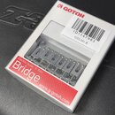 Bílé papírové balení s logem GOTOH obsahuje kovový kobylku na elektrickou kytaru. Na obalu je červený nápis Bridge, text Electric Guitar & Bass a web…