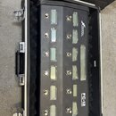 Černý MIDI kontrolér s dvanácti stisknutelnými spínači, z nichž každý má vedle malý displej. Na pravé straně je nápis FRACTAL AUDIO SYSTEMS a FC-12 F…
