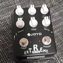 Černý kytarový efekt s bílými ovládacími knoflíky. Na šasi je uveden nápis JOYO EXTREME METAL a označení ovládacích prvků DRIVE, LEVEL a BOOST. Jsou…