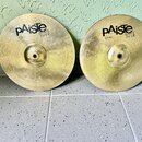 Dvě mosazné činely typu hi-hat v zlatavé barvě s koncentrickým žilováním. Oba mají černý nápis pAiste 101 BRASS a pod ním označení 12" HI-HAT. Povrch…