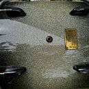 Detail na přední stranu basového bubnu s kovovým povrchem v barvě stříbrného třpytivého glitru. Na bubnu je umístěna zlatá kovová plákovka s nápisem…
