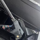 Černá elektrická kytara s lesklým povrchem v otevřeném černém kufru. Na kytaru je připojený černý popruh. V dolní části těla je vidět malá zlatavá ná…