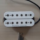 Bílý humbucker s dvěma řadami šesti polových magnetů. Na spodním rámečku je černý nápis Seymour Duncan. K snímači vede černý kabel a vedle něj jsou p…