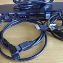 Černý audio rozhraní s nápisem MOTU a označením DigiMix 16 Mixer. Před přístrojem leží několik černých kabelů, z nichž jeden má USB konektor a bílou…