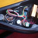 Fotografie zachycuje vnitřek elektroniky hudebního nástroje v černém plastovém nebo lakovaném šasi. Jsou zde vidět barevné vodiče, elektronické součá…