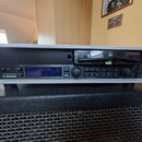 Stříbrný rackový efektový procesor značky tc electronic s modelem SYSTEM 20. Zařízení má černý přední panel s modrým displejem, několika tlačítky a d…