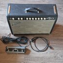 Kytarový kombo zesilovač s černým povrchem a světle šedou mřížkou. Na horním ovládacím panelu je nápis Super Sonic a pod ním Fender MUSICAL INSTRUMEN…