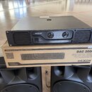 Černý rackový koncový zesilovač s nápisem DEXON a DAC 2000. Na předním panelu jsou dvě otočné kontrolky hlasitosti, přepínač POWER a červený nápis PO…