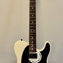 Bílá elektrická kytara s černým pickguardem a hnědým hmatníkem. Na hlavě je viditelné logo Fender a na pickguardu nápis Fender Mono-caster. Nástroj j…