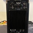 Zadní strana černého kytarového komba s koženým potahem a kovovými rohy. V horní části je logo AAD by Phil Jones a nápisy CUB - GUITAR AMPLIFIER, CUB…