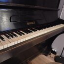 Černý pianino s klaviatura z bílých a černých kláves. Nad klávesami je v horní části nápis BROZ. Povrch nástroje vykazuje drobné škrábance a opotřebe…