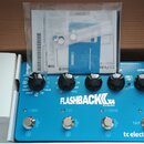 Modrý kytarový efekt s nápisem FLASHBACK X4 DELAY AND LOOPER a logem tc electronic. Zařízení má čtyři černé ovládací knoflíky, tři stoupací spínače o…