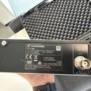 Černý rackový přijímač značky SENNHEISER, model EW-D EM. Na zadní straně je vidět nápis Diversity Rack Receiver, Freq. Range: R4-9 552 - 607.8 MHz, P…