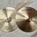 Dvě mosazné činely s viditelným rýhováním povrchu. Oba mají nápisy istanbul Agop Handmade cymbals from Turkey a v dolní části logo TRADITIONAL. Povrc…