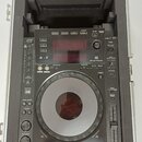 Černý DJ player Pioneer CDJ-900 umístěný v transportním kufru s pěnovou výplní. Na přístroji je vidět nápis Pioneer a v pravém dolním rohu označení M…
