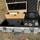 Černý externí napájecí zdroj s nápisem MZH-Tronics na horní straně. Na předním panelu jsou přepínače PAD a FILTER, konektory MIC INPUT a OUTPUT, vstu…