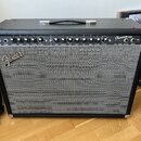 Černý kytarový kombo zesilovač s šedou síťovkou. Na horním ovládacím panelu je nápis Champion 100 a řada ovládacích knoflíků s popisky. Na přední str…