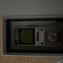 Kompaktní digitální ladička v bílém obalu s pěnovou výplní. Na přístroji je nápis Minitune a označení A4 FLAT, v pravé části je logo revoltage. Zaříz…