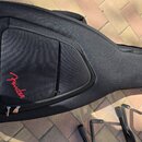 Černý polovrtvný pouzdro na kytaru z textilního materiálu. Na přední straně je vyšívané červené logo Fender. Pouzdro má zipové kapsy a je položené na…