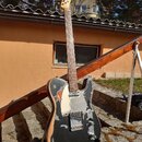 Elektrická kytara s černým lakem, který je v několika místech výrazně odloupaný a odhaluje světlé dřevo. Nástroj má bílý pickguard, jeden humbuker u…