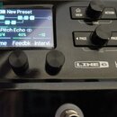 Detailní záběr na ovládací panel černého efektového procesoru s nápisem LINE 6 HX ST. Na displeji je zobrazen preset „03B New Preset“ s nastavením ef…