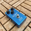 Modrý kytarový efekt s nápisy 427 DISTORTION a bbe. Na horní straně jsou tři černé otočné knoflíky s popisky LEVEL, GAIN a TONE. V pravé části je umí…