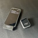 Na fotografii je bezdrátový mikrofonní systém značky SYNCO v šedé barvě. Sestává z přijímače s nápisem SYNCO Receiver, který je připojen k telefonu,…