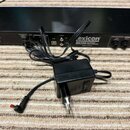 Černý rackový efektový procesor s nápisem exicon MX200 Multi Effects Processor a poznámkou Made in China. Přední panel obsahuje různé vstupy, výjupy…