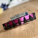 Kytarový efekt v černé šasi s fialovým horním panelem. Na panelu jsou nápisy DRIVE, BRITE, BASS, MIDDLE PULL CHANNEL, TREBLE a MASTER PULL MODERN, vp…