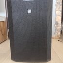 Černý reproduktor s kovovou mřížkou v六úhlíkovém vzoru. Uprostřed přední strany je umístěno stříbrné logo LD. Povrch přístroje vypadá čistý a v dobrém…