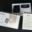Sada bezdrátového mikrofonu v bílém originálním balení. Na krabici i na zařízeních je logo SYNCO a nápisy G1T/G1L, DIGITAL 2.4GHz, 1-TRIGGER-1 WIRELE…