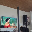 Na fotografii je černý reproduktorový systém s vysokým, štíhlým sloupcem a samostatným subwooferem. Na přední straně subwooferu je bílý nápis BOSE. V…