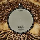 Elektronický buben v černé barvě s bílou pukulovou plochou. Na horní části je nápis Roland a pod ním text Head made by REMO U.S.A. Ve spodní části je…