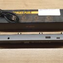 Černý obdélníkový přístroj s několika konektory a USB portem, na jeho spodní straně je nápis M-VAVE. Vedle něj leží černá krabice s nápisem COLATE PL…