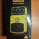 Fotografie zachycuje černý kartonový obal efektového pedálu. Na krabici je zobrazen žlutý pedal s nápisy UC200, ULTRA CHORUS a značkou behringer. Jso…