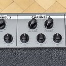 Detail ovládacího panelu zesilovače s nápisem Peavey KB 5. Panel obsahuje čtyři kanály (CHANNEL 1, CHANNEL 2, CHANNEL 3 a CHANNEL 4) s ovládacími prv…