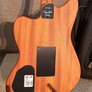 Zadní strana elektrické kytary s přírodním dřevěným povrchem. Na krku je vidět nápis US223042A a logo Fender s doplňkem CORONA, CALIFORNIA. Tělo kyta…