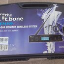 Černý plastový kufr s nápisem the t.bone IEM100 IN-EAR MONITOR WIRELESS SYSTEM a rozsahem 863.000~865.000MHz. Na povrchu je obrázek vysílače s nápise…