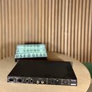 Zadní strana černého rackového audio rozhraní značky Focusrite, model Scarlett 18i20. Jsou zde viditelné různé konektory, včetně vstupů XLR a jack, W…