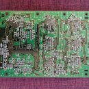 Zelená tiskovaná spoje s osazenými elektronickými součástkami. Na desce jsou viditelné nápisy KLM-2076-1 v horní části. Povrch desky vykazuje běžné z…
