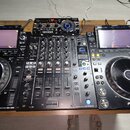 Sada DJského vybavení tvořená dvěma kontrolérymi Pioneer DJ CDJ-3000 a centrálním mixérem Pioneer DJ DJM-900NXS2. V horní části nad mixérem je umístě…