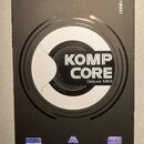 Černá krabice od efektového pedálu s nápisem NUX v horní části. Uprostřed je bílý kruh s textem KOMP CORE Deluxe MKII. Ve spodní části jsou loga a ná…